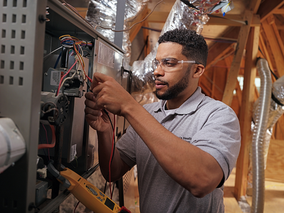 Experienced HVAC technician using precision tools on a sophisticated AC system in Highland Park, TX